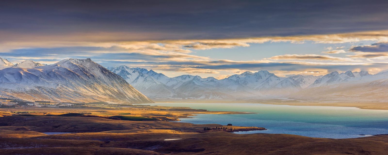 Sunrise over glimmering azure blue Lake Tekapo and snow-covered mountains, New Zealand